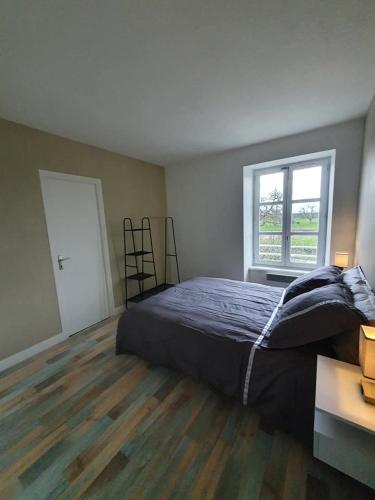 a bedroom with a bed and a window at Le bien être aux forges in Céaux
