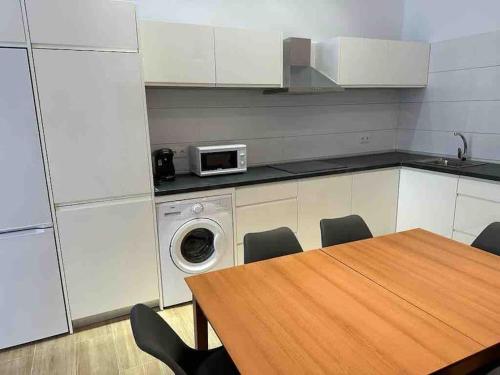 a kitchen with a table and a washing machine at Apartamento Murcia San José B in Murcia
