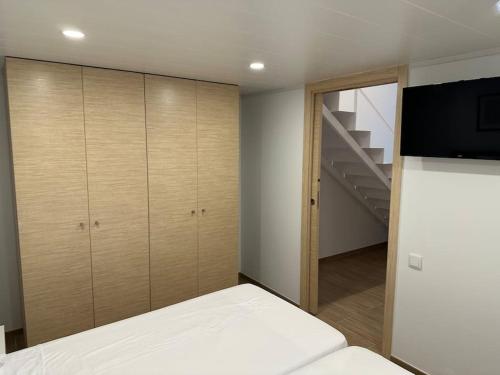 a bedroom with a bed and a tv and a staircase at Apartamento Murcia San José B in Murcia