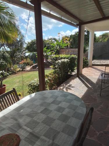 a table on a patio with a view of a yard at Villa baie diamant in Rodrigues Island