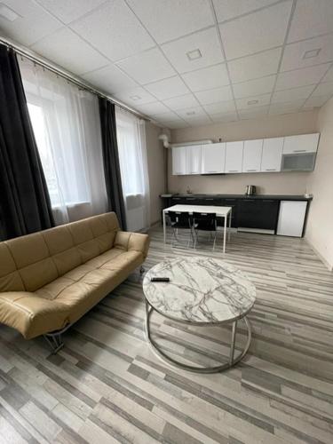 a living room with a couch and a table at Brēžas apartamenti in Valmiera