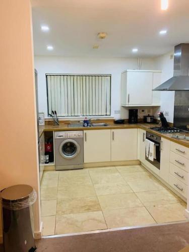 a kitchen with a washer and a washing machine in it at Marigold Private double room in London