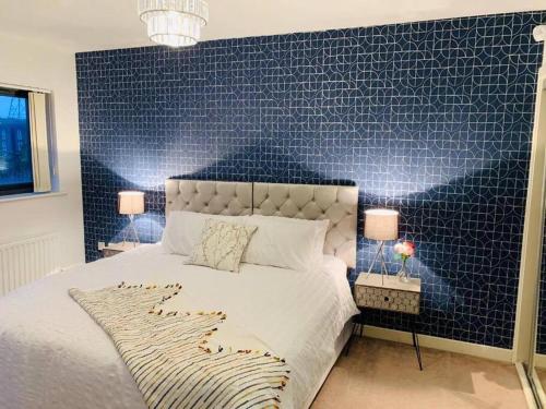 a bedroom with a large bed with a blue accent wall at Marigold Private double room in London
