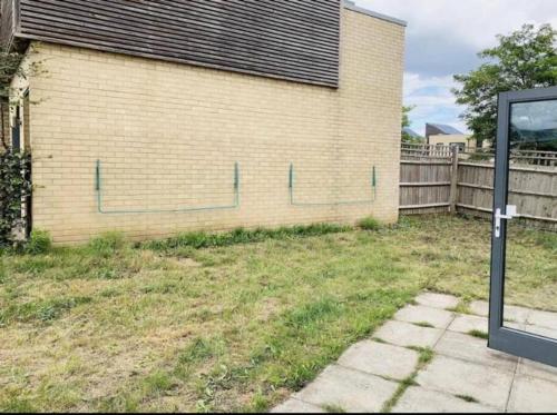 a brick building with a fence in a yard at Marigold Private double room in London