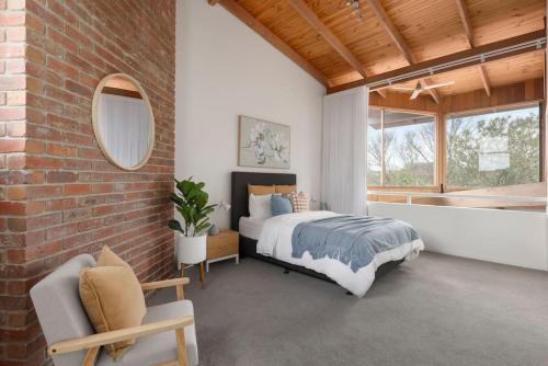a bedroom with a bed and a brick wall at Surfcoast Soul - Stylish Dog Friendly Retreat - Torquay in Torquay
