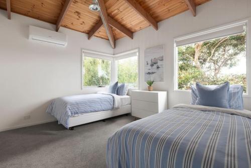 a bedroom with two beds and two windows at Surfcoast Soul - Stylish Dog Friendly Retreat - Torquay in Torquay