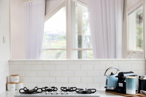 a kitchen counter with a stove and a window at Surfcoast Soul - Stylish Dog Friendly Retreat - Torquay in Torquay