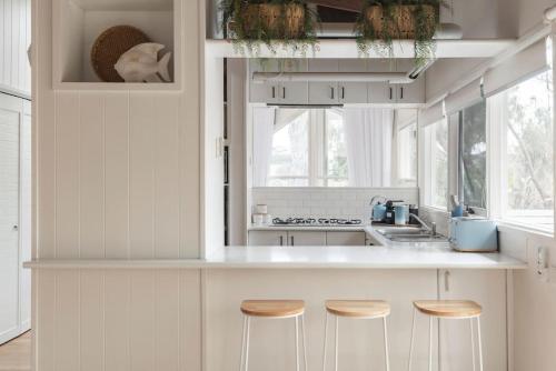 a kitchen with a counter with stools in it at Surfcoast Soul - Stylish Dog Friendly Retreat - Torquay in Torquay