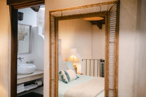 a mirror in a bathroom with a bed and a sink at Boutique Villa in Antigua in Antigua Guatemala