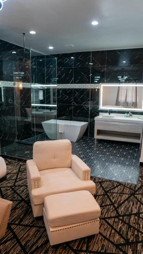 a bathroom with a couch and a tub and a chair at Comfeeni Inn and Suites in Houston