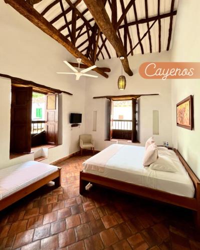 a bedroom with two beds and a ceiling at Misia Custodia Hotel Boutique in Barichara