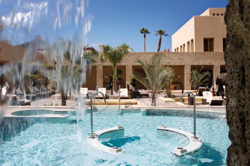 a swimming pool with a fountain in a resort at The Villas at Bahia del Duque in Adeje