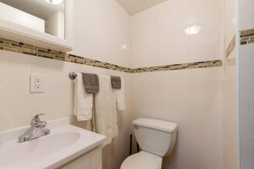 ein weißes Bad mit einem WC und einem Waschbecken in der Unterkunft Large Queen Bed Apt with Workstation in New York