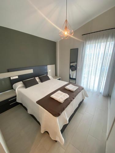 a bedroom with a large bed and a large window at La Palmera del Sotillo in La Lastrilla