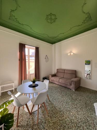 a living room with a table and chairs and a couch at Valguarnera Studio Apartments in Palermo