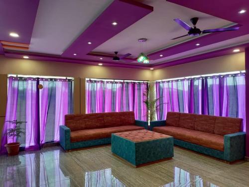 a living room with two couches and purple curtains at The Nirvana Resort in Chatra