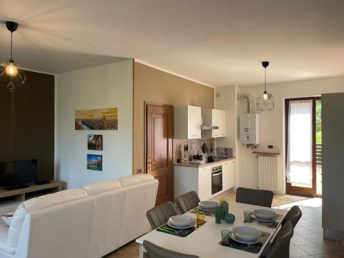 ein Wohnzimmer mit einem Tisch und einem weißen Sofa in der Unterkunft [The window On The Valdadige] Sport and Nature 