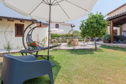 a patio with an umbrella and a table and chairs at Siracusa mare in Arenella