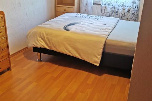 a bed in a bedroom with a wooden floor at Maison Room in Karlsruhe