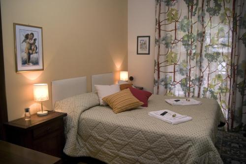 - une chambre avec un lit et une serviette dans l'établissement B&B La Cittadella Univeristaria Policlinico Catania, à Catane