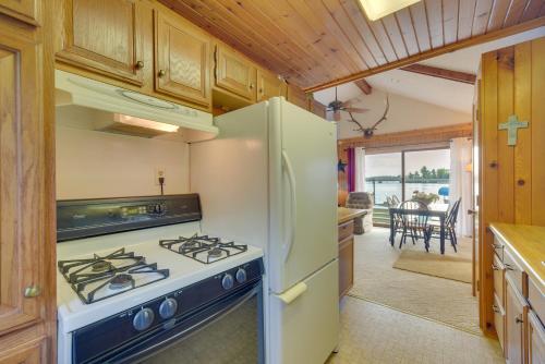 a kitchen with a white refrigerator and a stove at Lakefront Chetek Vacation Rental with Private Dock! in Chetek