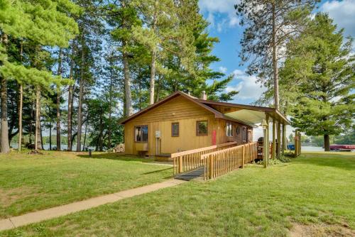 a small cabin with a porch in a park at Lakefront Chetek Vacation Rental with Private Dock! in Chetek