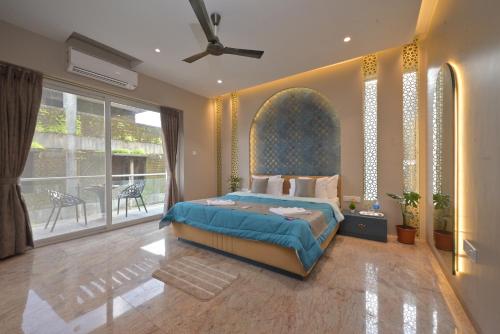 een slaapkamer met een bed en een groot raam bij Orchid Paradise Villa by Tropicana Stays in Lonavala