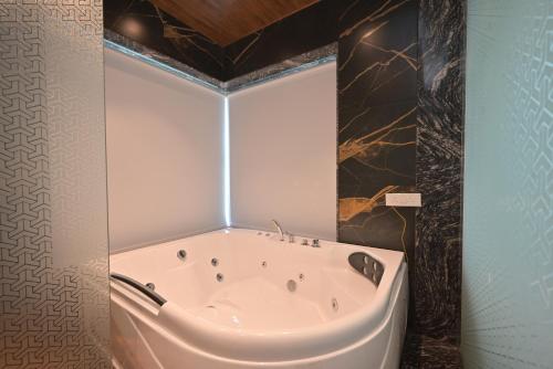 een badkamer met een bad in de kamer bij Orchid Paradise Villa by Tropicana Stays in Lonavala