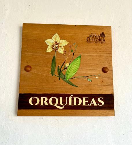 a wooden sign with a yellow flower on it at Misia Custodia Hotel Boutique in Barichara