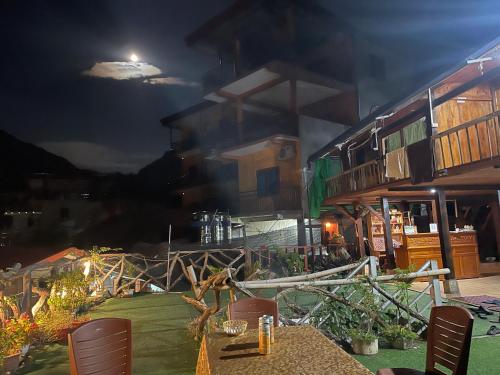 a table with chairs in front of a building at night at Ba Bể Green (View Ba Be lake) in Bak Kan