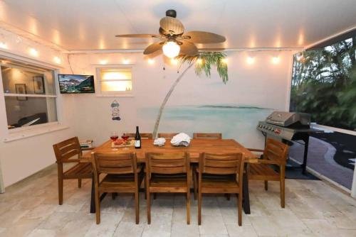 Greenacres CityThe Utopia Resort Dream Pool BBQ Outdoor Dining的一间带桌子和钢琴的用餐室