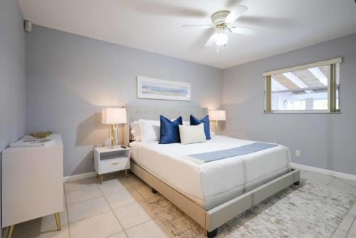 1 dormitorio con 1 cama grande con almohadas azules en The Utopia Resort Dream Pool BBQ Outdoor Dining, en Greenacres City