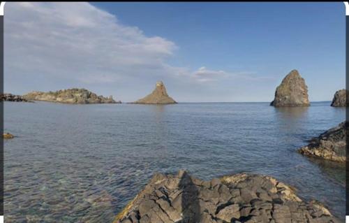 a group of islands in the water with rocks at Faraglioni inn in Acitrezza