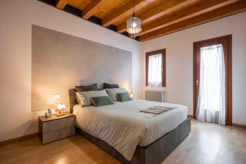 a bedroom with a large bed and a large window at [Venezia-Suite Hemingway]a pochi passi Outlet in Noventa di Piave