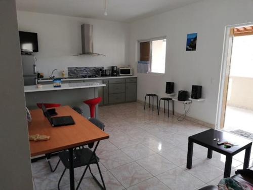 a kitchen and living room with a table and chairs at Casa Yô in Mindelo