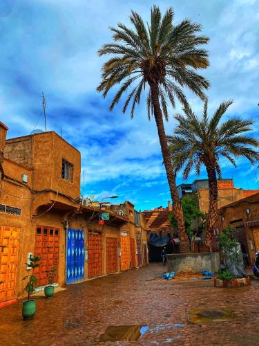 two palm trees and buildings in a city at Riad Al Nour in Marrakech