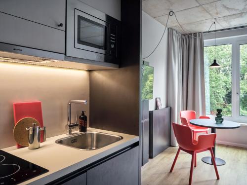 a kitchen with a sink and a table at STAYERY Bremen in Bremen