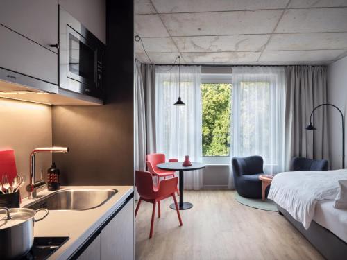a kitchen and a bedroom with a bed and a table at STAYERY Bremen in Bremen