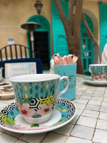 a coffee cup on a plate on a table at Riad Al Nour in Marrakech