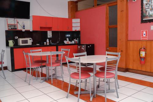 een keuken met rode kasten en een tafel en stoelen bij Yaki Hostel in Lima