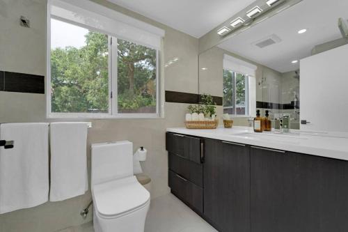a bathroom with a toilet and a sink and a window at Casa Copal: Relaxing Beach House in Hollywood
