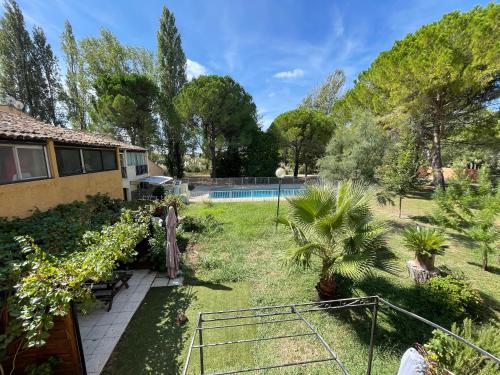 un jardin avec une piscine et une maison dans l'établissement Appartement 211 Les Salicornes, à Arles