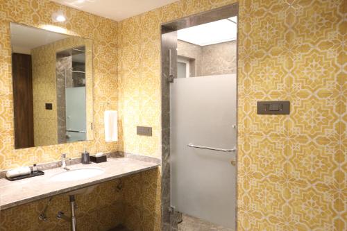 a bathroom with a sink and a mirror and a shower at Golden Fields Resort in Mulshi