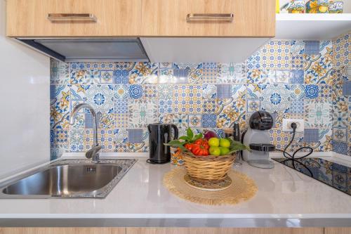 a kitchen with a sink and a basket of fruit at Siracusa mare in Arenella