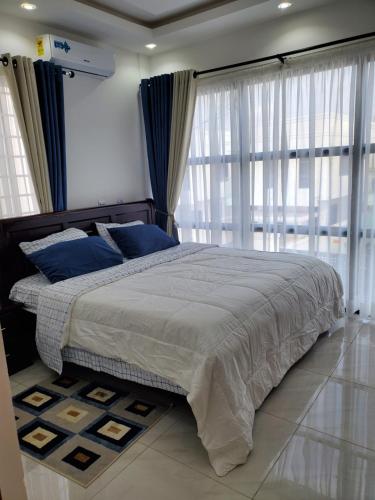 a bedroom with a large bed and a large window at Home away from home #1 in Accra