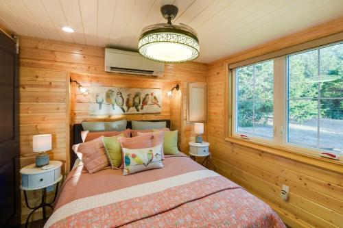 1 dormitorio con paredes de madera y 1 cama con almohadas en Whitney Retreat with Shared Outdoor Pool and Hot Tub!, en Whitney