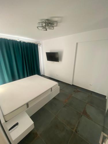 - une chambre avec un lit blanc et un rideau vert dans l'établissement Dari guesthouse, à Râmnicu Vâlcea