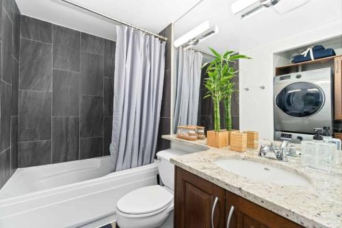 ein Badezimmer mit einem Waschbecken, einem WC und einer Badewanne in der Unterkunft 2BR Condo with breathtaking view in Downtown! Free parking - 6 sleep in Vancouver