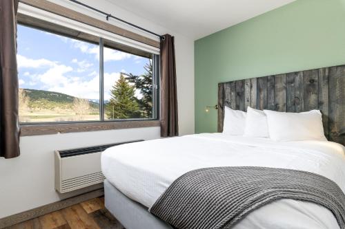 Un dormitorio con una cama grande y una ventana en MTN Lodge Ridgway, en Ridgway