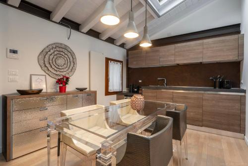 a dining room with a glass table in a kitchen at [Elegant Suite Piave]Venezia Outlet in Noventa di Piave